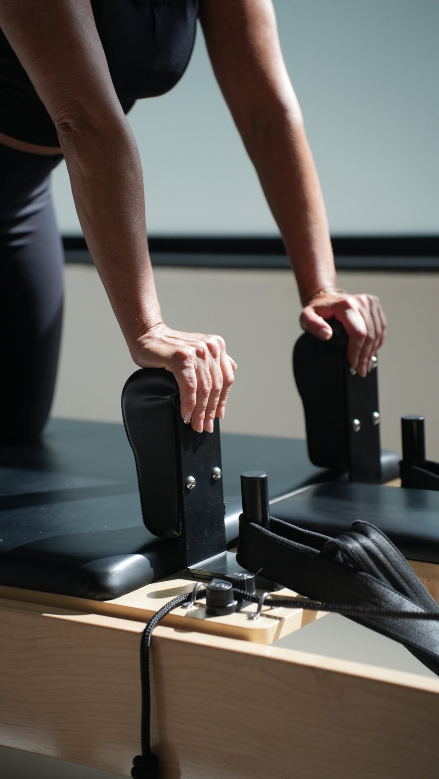 Detalle de manos en una máquina de pilates